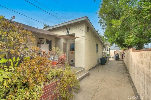 a view of a small house with wooden fence