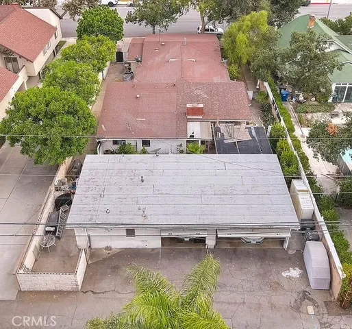 an aerial view of a house with swimming pool and large trees