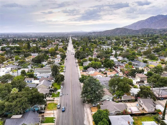 an aerial view of residential houses with outdoor space and trees