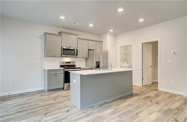 a kitchen with stainless steel appliances granite countertop a stove a sink and a refrigerator