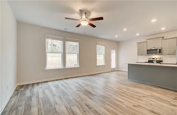 a view of an empty room with window and wooden floor