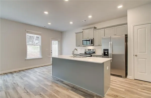 a kitchen with kitchen island a sink stainless steel appliances and window