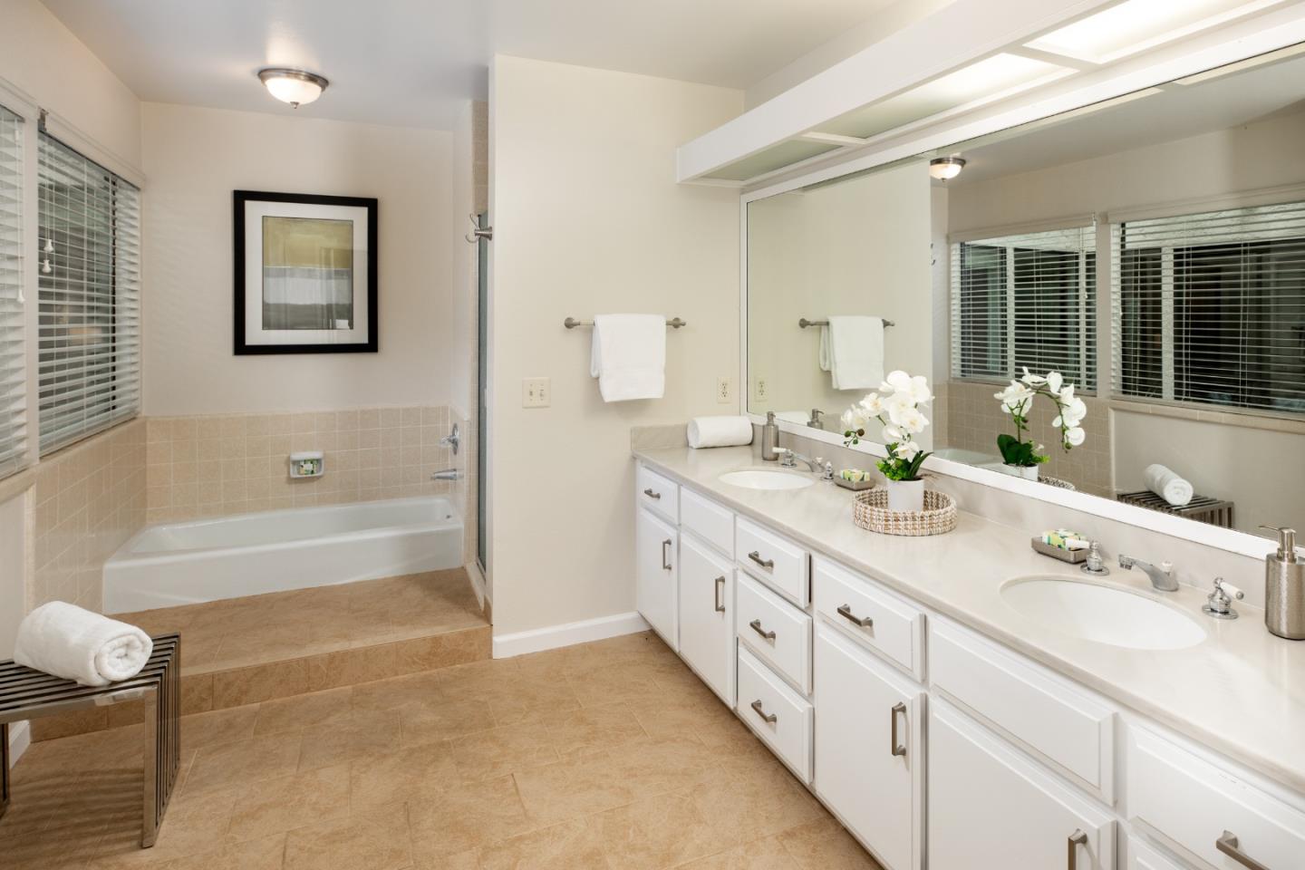 22415 Rancho Deep Cliff Drive Cupertino, CA 95014 - Photo 16 of 33 a bathroom with double vanity two mirror a bathtub and a double vanity sink