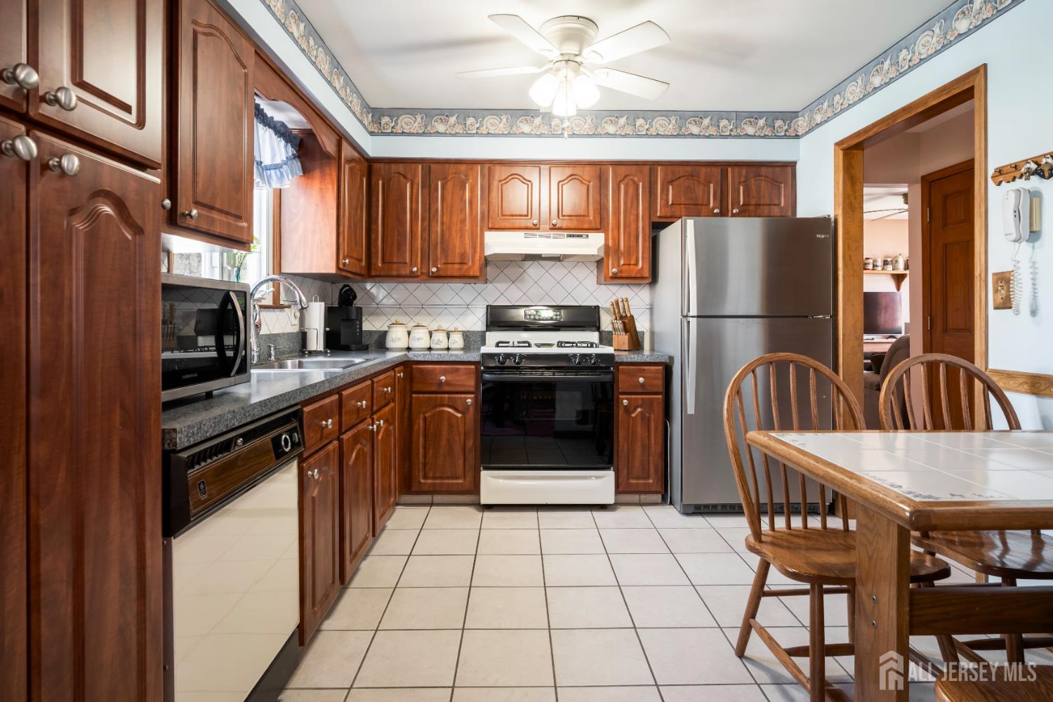 6 Marie Lane Edison, NJ 08817 - Photo 12 of 35 a kitchen with stainless steel appliances granite countertop a stove top oven a refrigerator a sink and a stove