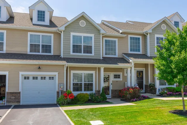 front view of a brick house with a yard