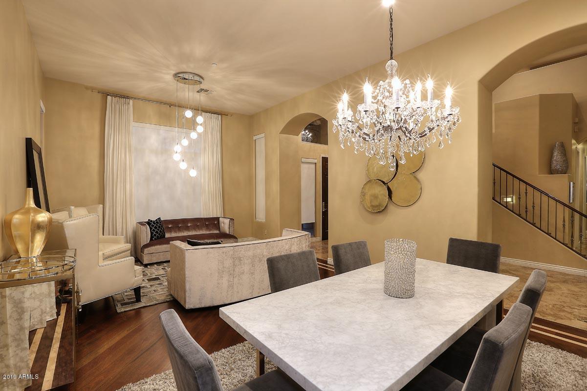 3736 East Maffeo Road Phoenix, AZ 85050 - Photo 7 of 62 a living room with furniture a chandelier and a dining table