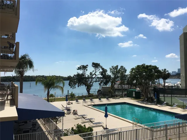 a swimming pool with outdoor seating and yard in back