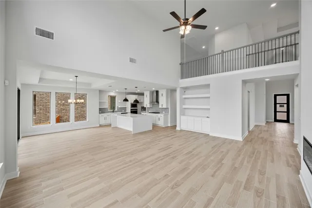 a view of a kitchen with wooden floor and a ceiling fan