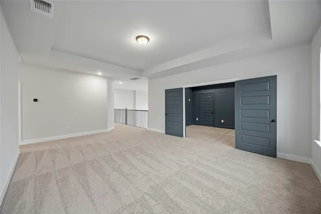 a view of an empty room with closet and entryway