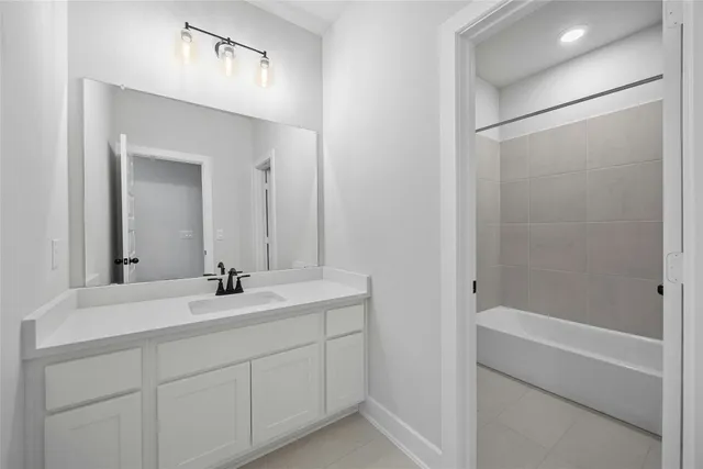 a bathroom with a bathtub sink vanity and mirror