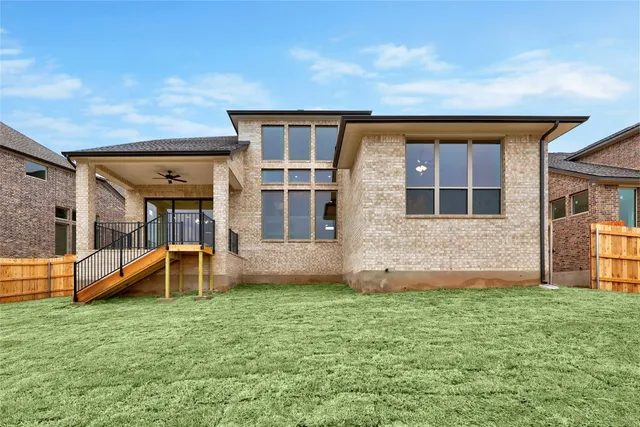 a view of an house with backyard space and balcony
