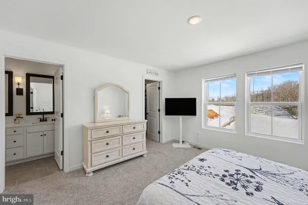 a bedroom with a bed a window and dresser