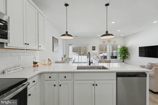 a kitchen with stainless steel appliances kitchen island granite countertop a sink a stove and cabinets