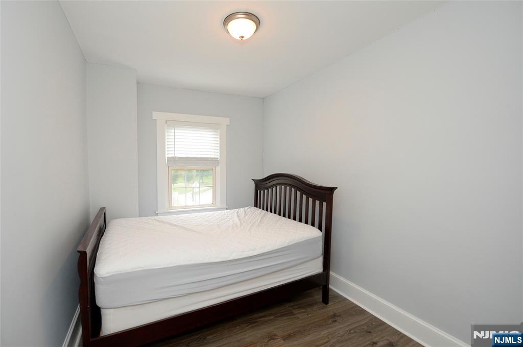 7 Main Street, Unit 2B Glen Rock, NJ 07452 - Photo 17 of 17 a bed sitting in a bedroom next to a window