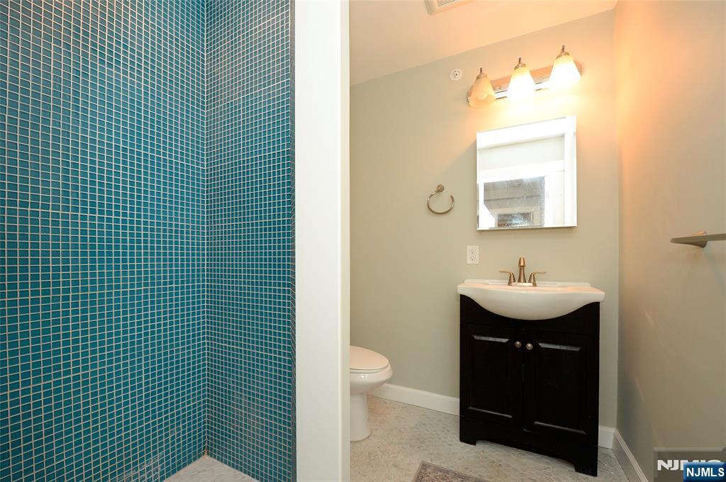 7 Main Street, Unit 2B Glen Rock, NJ 07452 - Photo 4 of 17 a bathroom with a sink a toilet and mirror