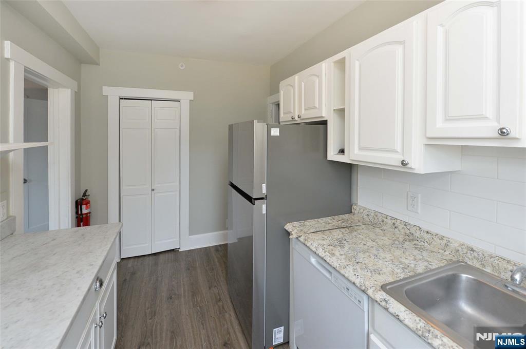 7 Main Street, Unit 2B Glen Rock, NJ 07452 - Photo 8 of 17 a kitchen with stainless steel appliances granite countertop a sink stove and refrigerator