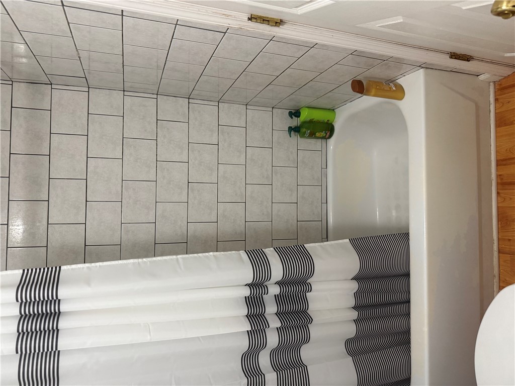 5840 Pitchin Road South Springfield, OH 45502 - Photo 6 of 18 This clean bathroom features tiled walls and a functional bathtub, creating a practical space.