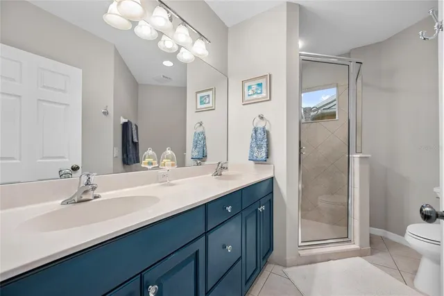 a bathroom with a double vanity sink mirror and toilet