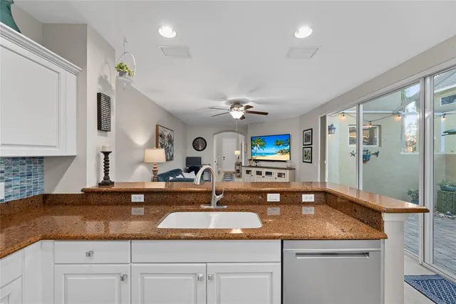 a bathroom with a granite countertop sink a mirror and shower
