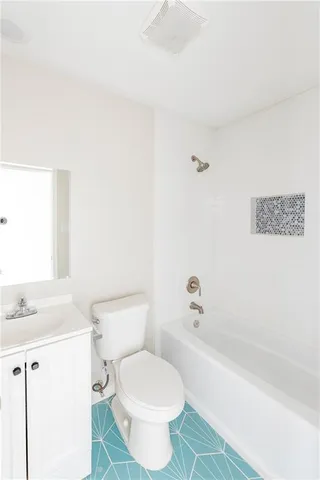 a white toilet sitting next to a bath tub