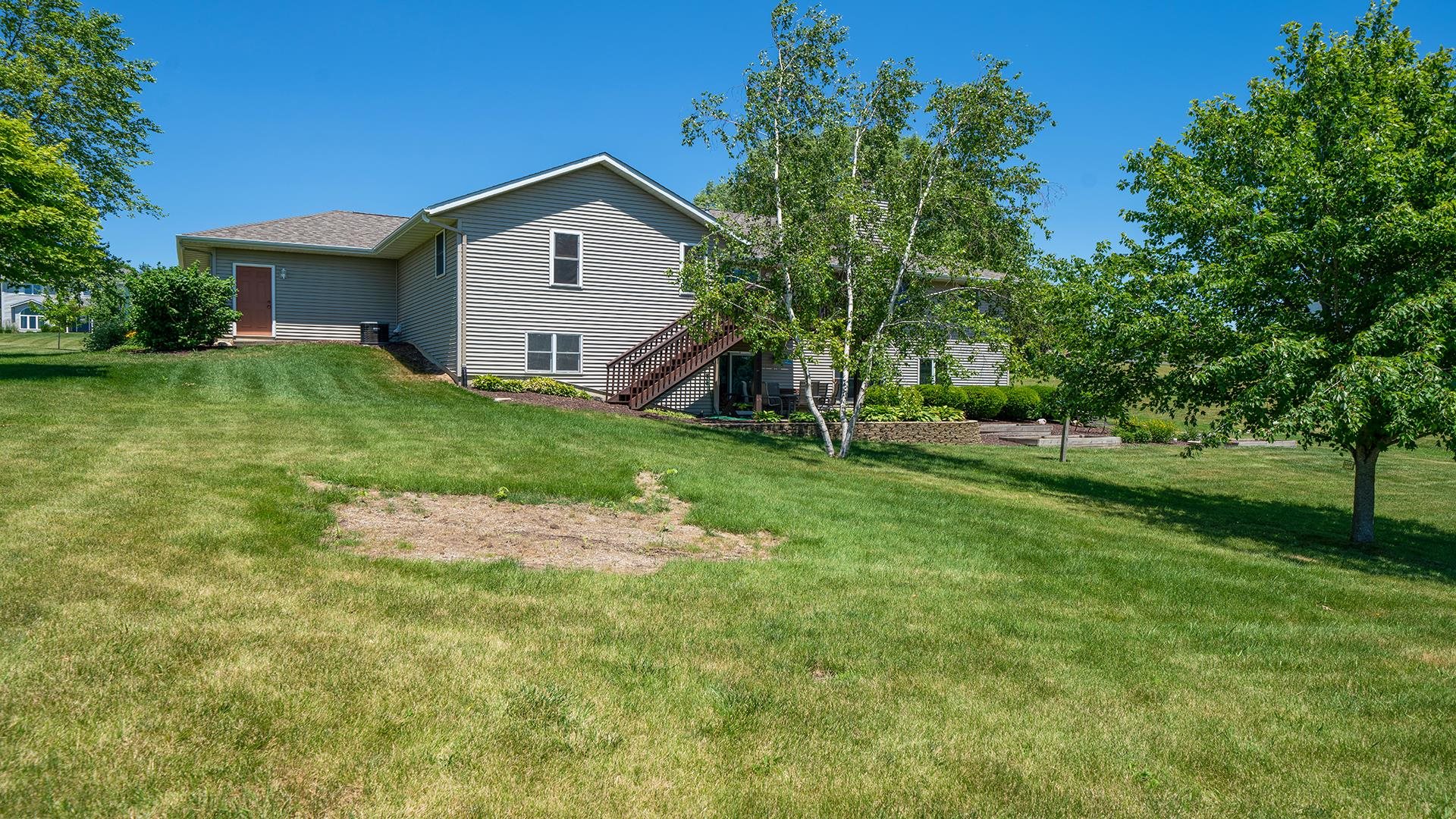 4317 Ridgeview Lane Byron, IL 61010 - Photo 32 of 41 a backyard of a house with plants and large tree