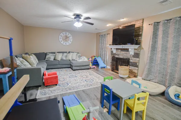 a living room with furniture and a flat screen tv with kitchen view