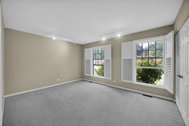a front view of a house with a yard and potted plants