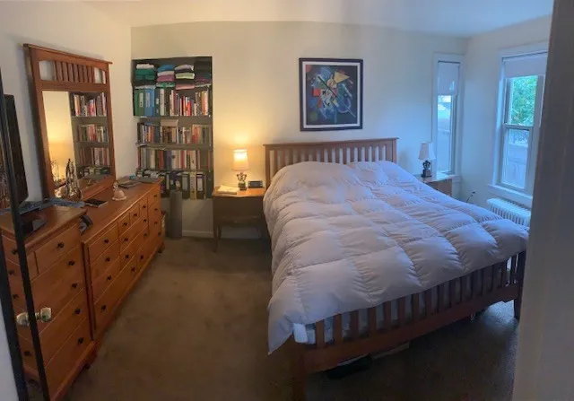 a spacious bedroom with a bed and a cabinets