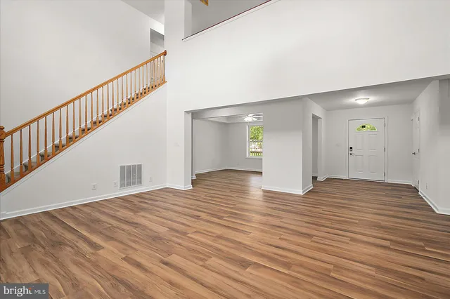 a kitchen with stainless steel appliances granite countertop a refrigerator a sink dishwasher a stove with wooden cabinets and wooden floor