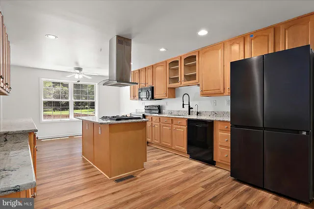 a kitchen with stainless steel appliances granite countertop a refrigerator and a stove top oven