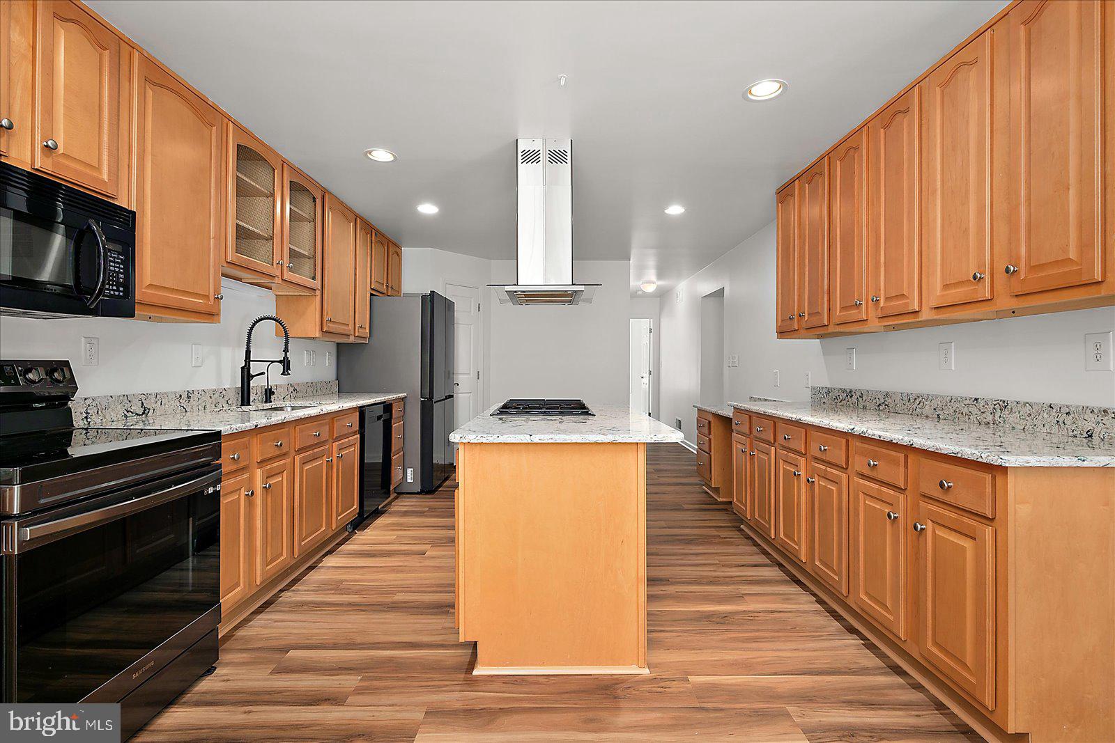 12212 Brant Road Bishopville, MD 21813 - Photo 24 of 69 a large kitchen with stainless steel appliances granite countertop a stove top oven a sink dishwasher and a microwave oven with wooden floor