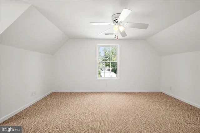 a view of an empty room with a ceiling fan