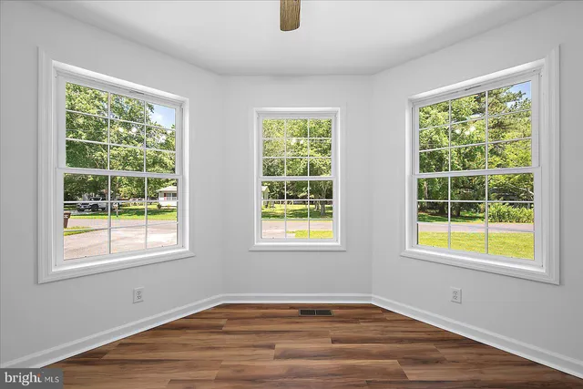 wooden floor in an empty room with a window