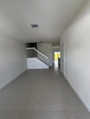 a view of an empty room and stairs