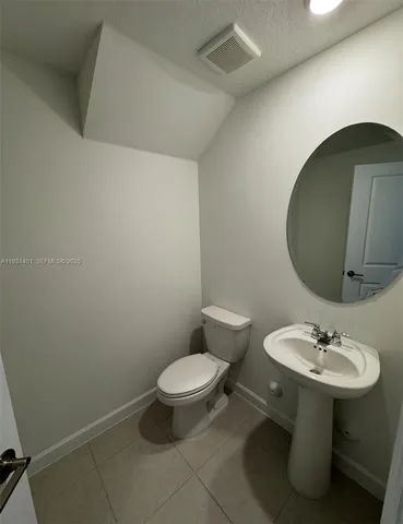 a bathroom with a sink toilet and a mirror