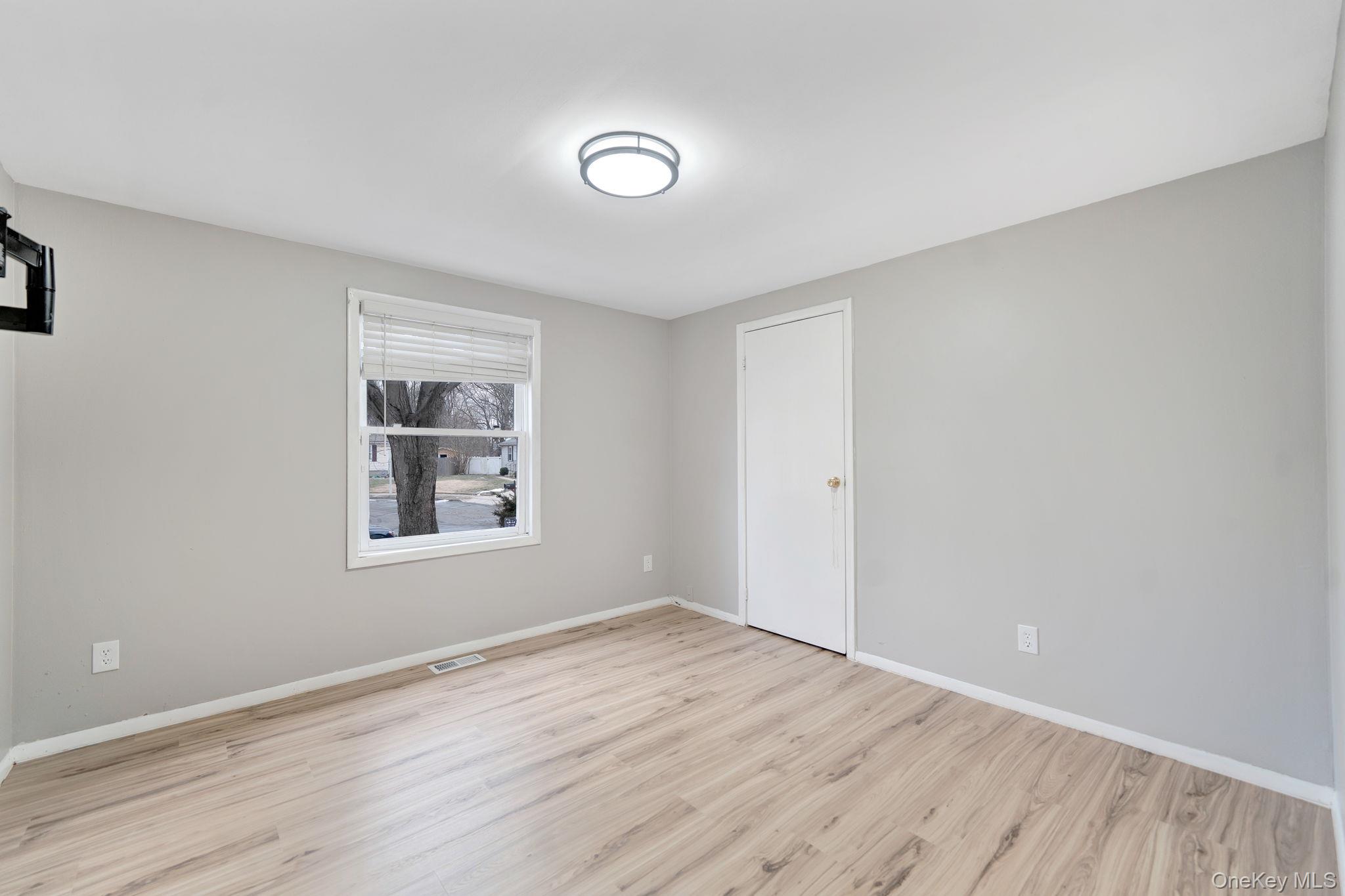 7 Kristin Court Bay Shore, NY 11706 - Photo 13 of 14 Unfurnished room featuring baseboards and light wood-style flooring
