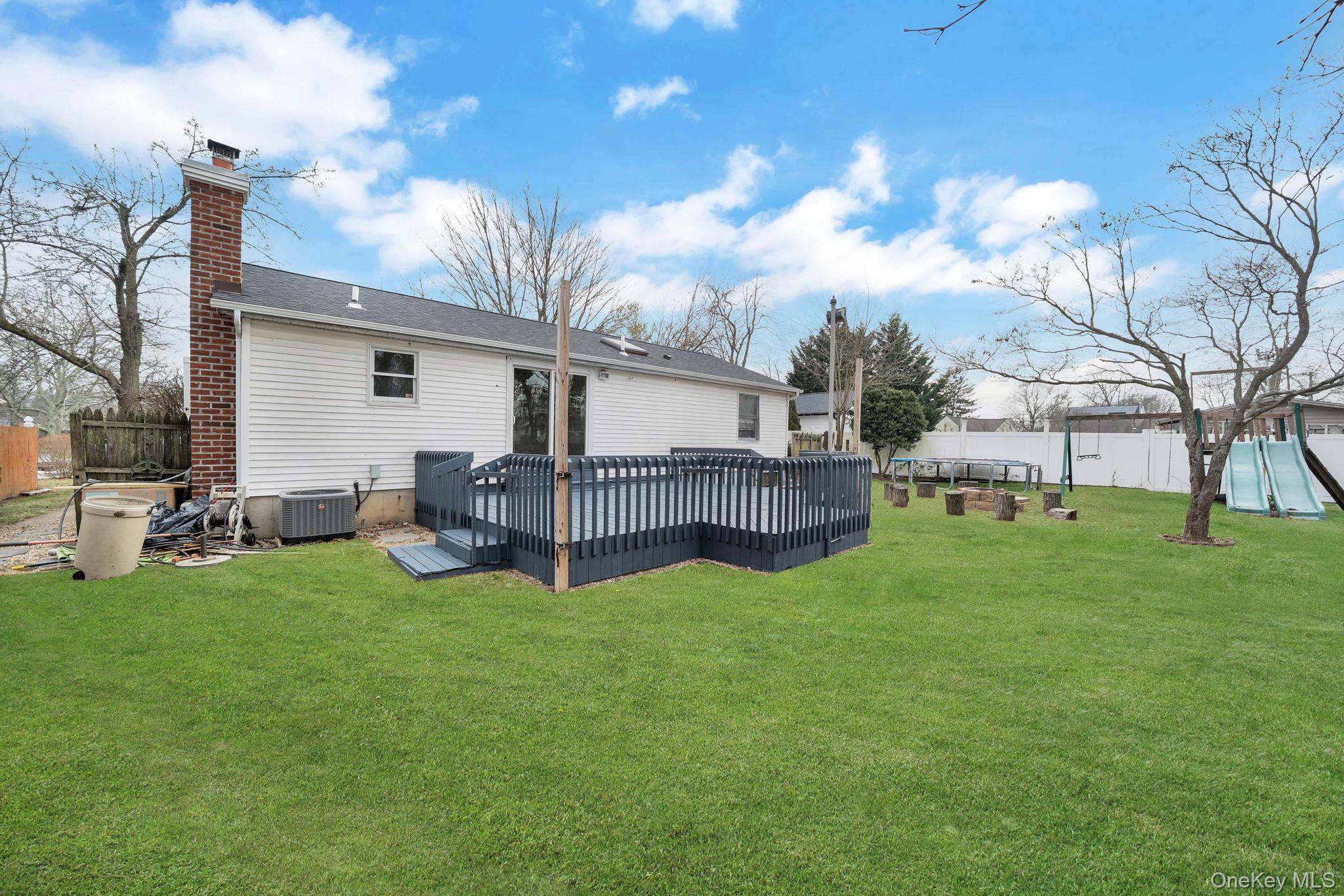 7 Kristin Court Bay Shore, NY 11706 - Photo 4 of 14 Rear view of house with a deck, a chimney, and roof with shingles