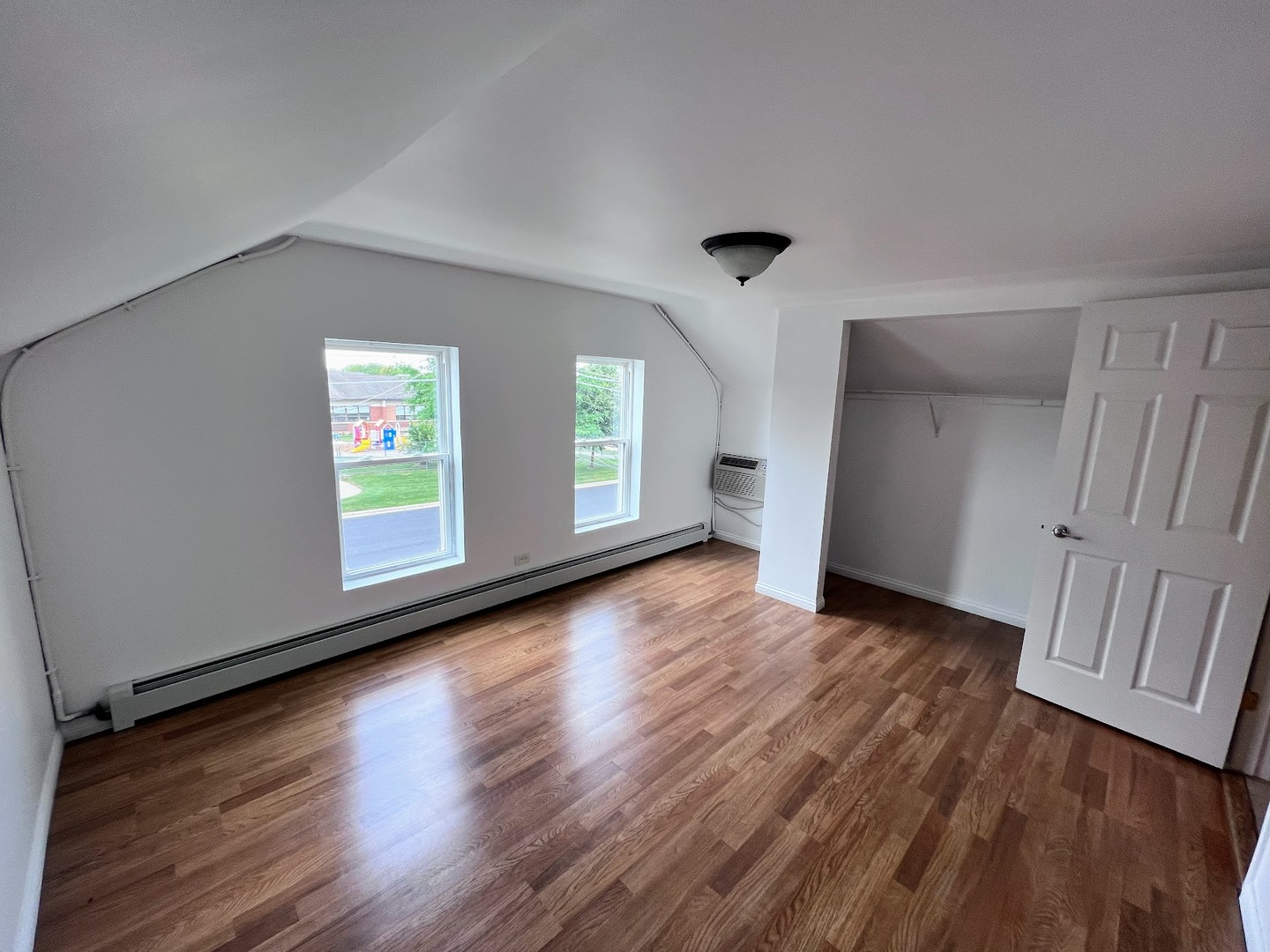 218 South Church Street, Unit 4 Wauconda, IL 60084 - Photo 7 of 11 an empty room with wooden floor and windows
