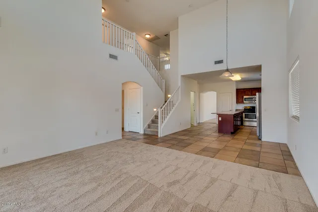 a view of a livingroom with wooden floor and stairs