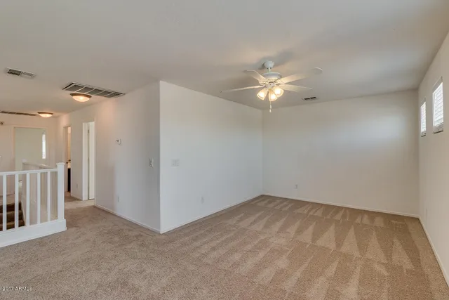 a view of an empty room with a ceiling fan
