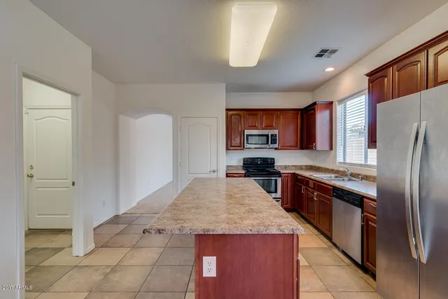 a kitchen with stainless steel appliances granite countertop a refrigerator and a stove