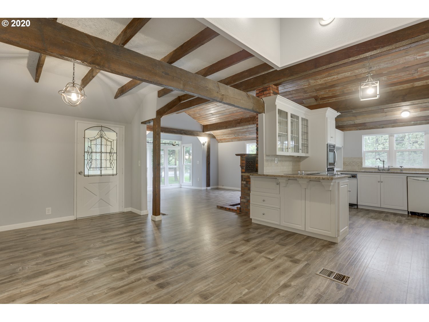 20379 South Ferguson Road Oregon City, OR 97045 - Photo 13 of 32 a view of an empty room with wooden floor and a kitchen