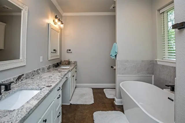 a bathroom with a granite countertop sink and a bathtub