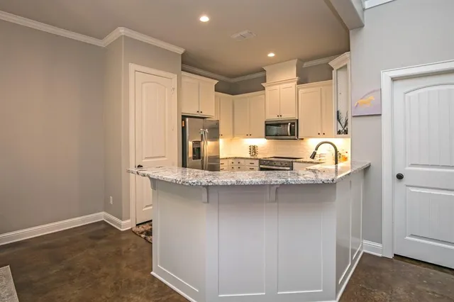 a kitchen with stainless steel appliances granite countertop a sink stove and refrigerator