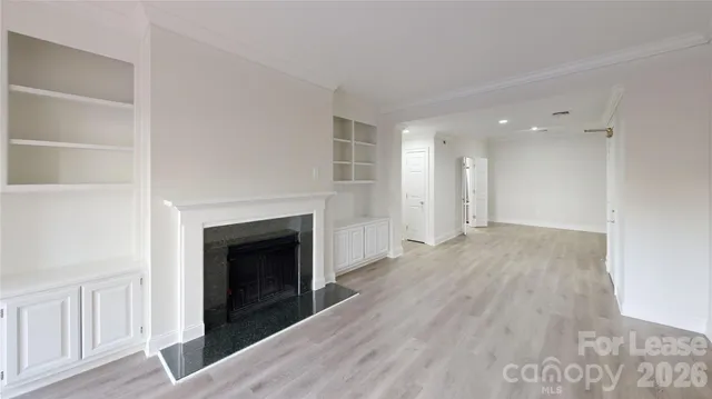 a view of a livingroom with wooden floor and a fireplace
