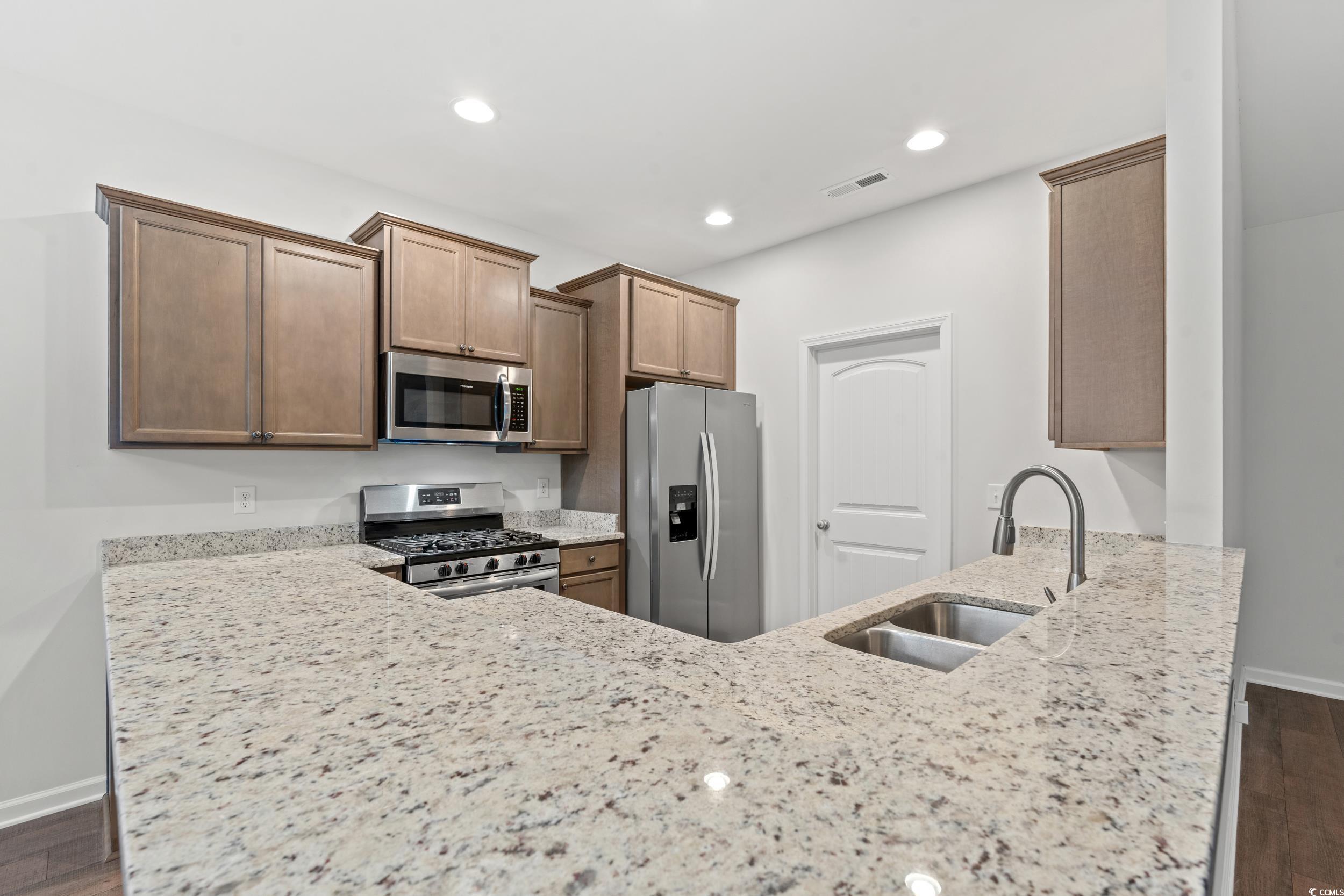 280 Palm Terrace Loop Conway, SC 29526 - Photo 14 of 29 Kitchen with light stone countertops, dark hardwoo