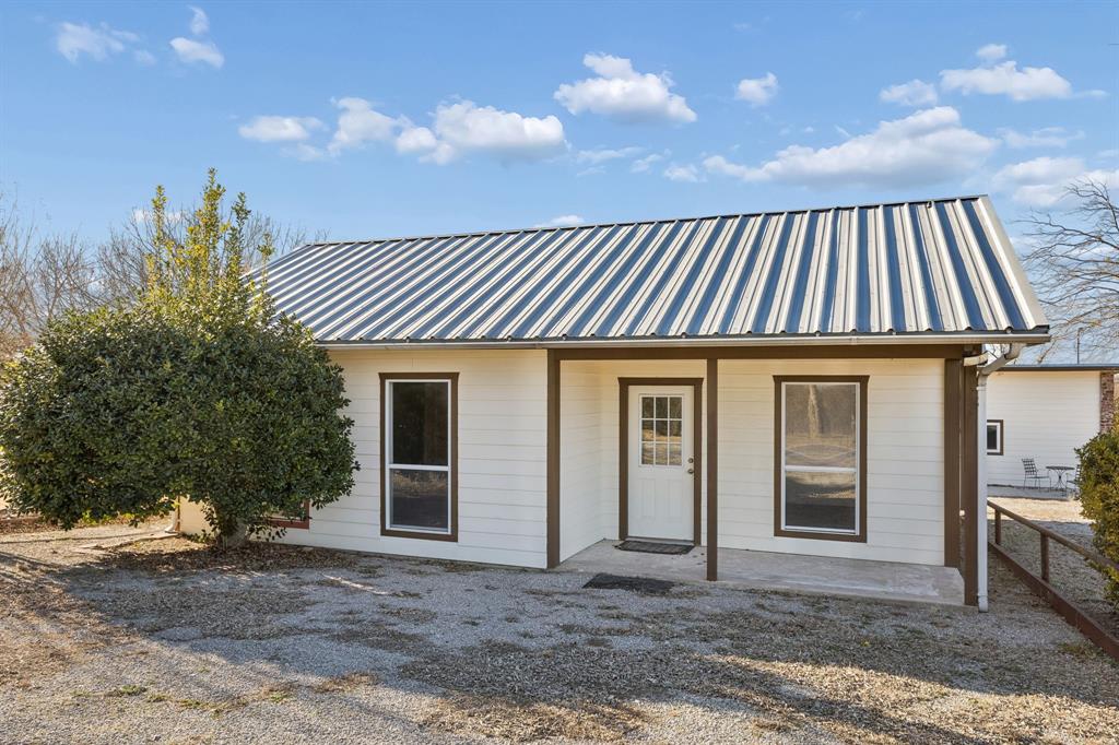 1922 A Bethel-Cannon Road Whitewright, TX 75491 - Photo 30 of 40 Exterior featuring white siding with brown trim, a metal roof, and a covered porch entry