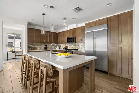 a kitchen with a refrigerator a sink and wooden floor