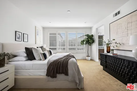 a bedroom with a bed and a large window