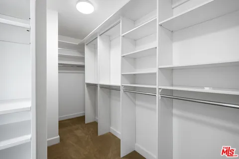 a view of walk in closet with empty racks